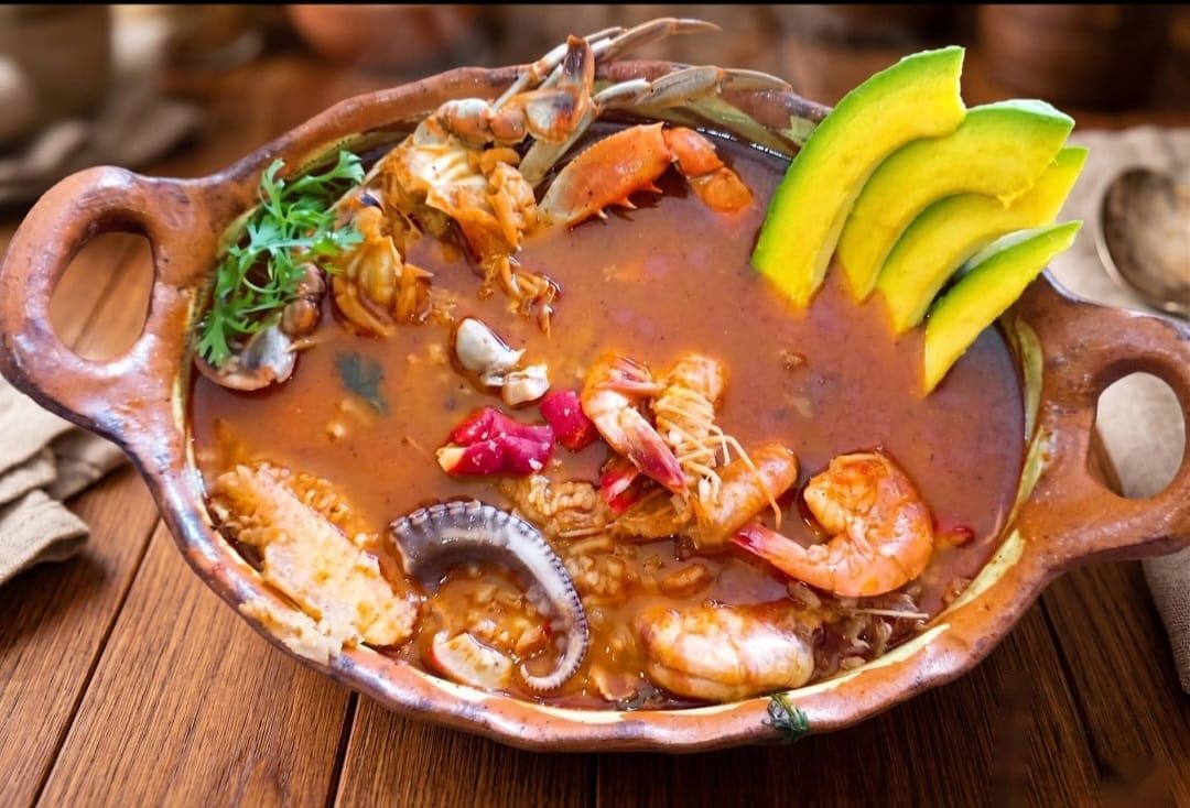 Arroz a la tumbada en cazuela de barro con camarones, jaiba, almejas y aguacate